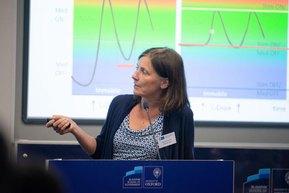 a presenter in front of slides, uses a laser pointer