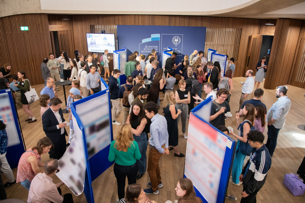 people standing around poster boards, discussing the posters