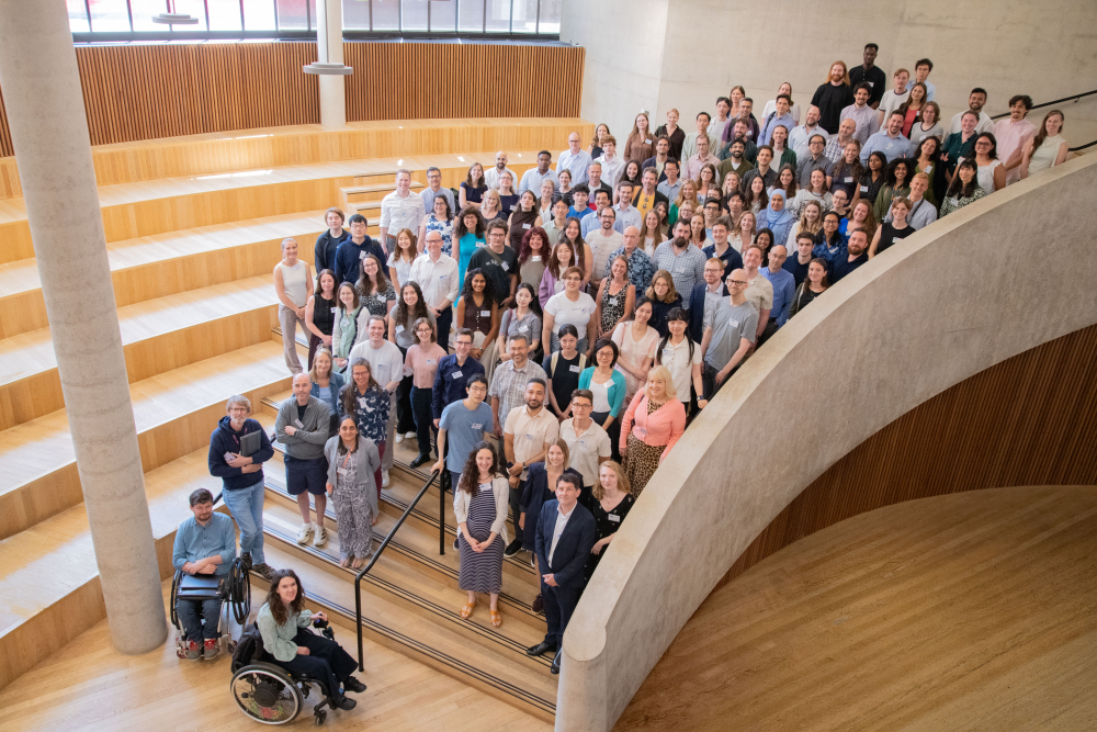 a large group of people in a modern building, on a curved staircase