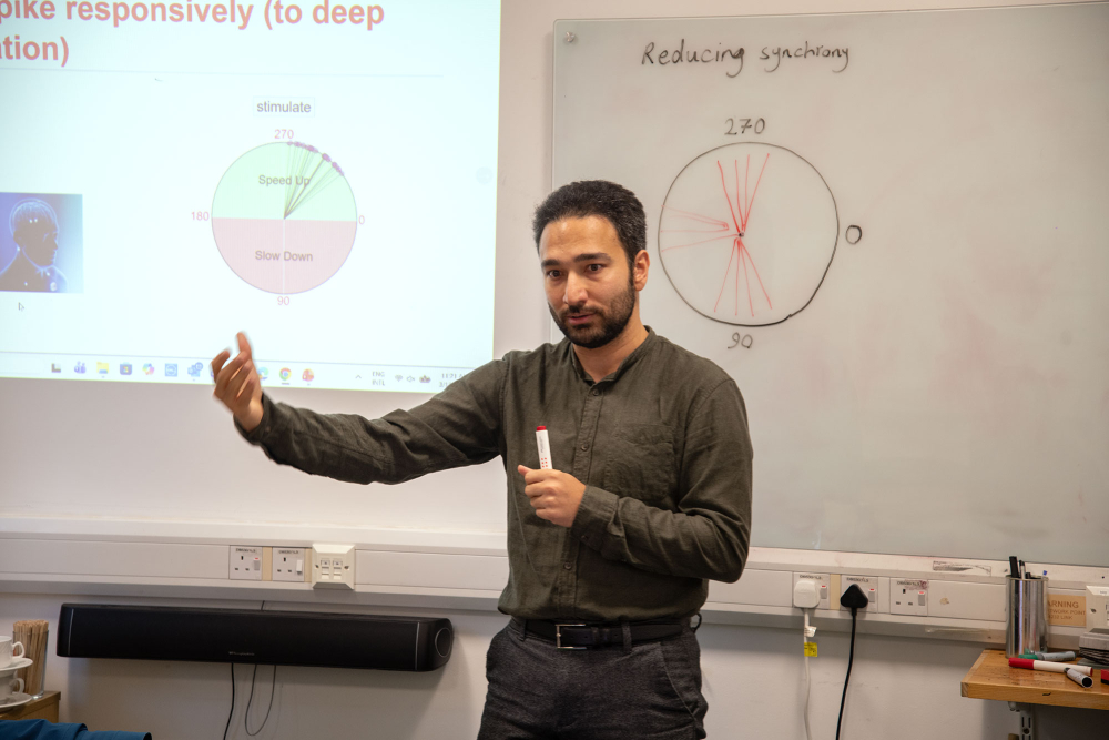 a researcher stands in front of a diargam, explaining